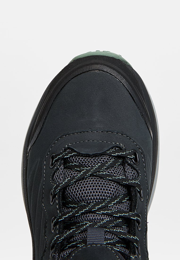 Chaussure de randonnée noire avec une tige texturée, des panneaux en mesh et des lacets contrastants. Elle dispose d'un embout renforcé et d'une semelle rembourrée pour un soutien accru.