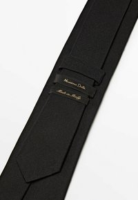 Nœud papillon en tissu texturé avec un design élégant. Présente deux étiquettes de marque en or : "Massimo Dutti" et "Fabriqué en Italie."