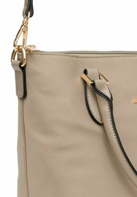 Borsa a tracolla sintetica beige con una trama liscia, dotata di rifiniture nere, accessori in oro e chiusura con zip. Le cinghie includono dettagli decorativi.