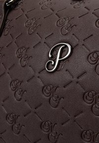Brown embossed leather handbag featuring a pattern of intertwined letters and a shiny silver letter "P" accent. Textured, minimalist design.