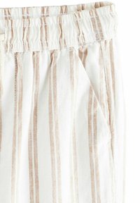 Lätta, vita tygbyxor med vertikala beige ränder, elastisk midja och sidofickor. Slät textur och avslappnad design.