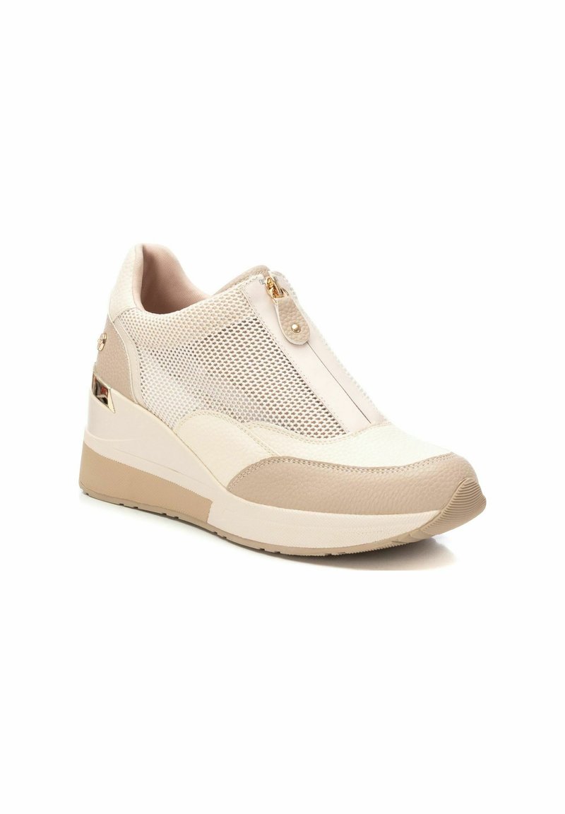 Sneakers con zeppa beige, con lati in mesh, dettagli in pelle testurizzata e una zip frontale. Presentano una suola di supporto e una design della punta arrotondata.