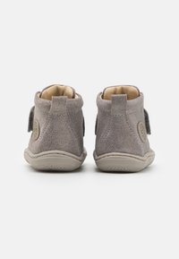 Botines de ante gris con forro interior suave, doble correa de Velcro y suelas de goma redondeadas con acabado texturizado.