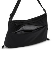 Černá kabelka přes rameno s hladkým, matným nylonovým povrchem, vybavená kapsou na zip, nastavitelným popruhem a stahovacími šňůrkami ve spodní části.