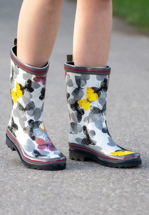 Bottes de pluie à motif avec une finition brillante, ornées d'un design de papillons en jaune, rose et gris. Semelle en caoutchouc noire avec adhérence.