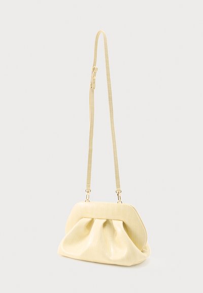 Αυθεντική τσάντα ώμου από απαλό δέρμα σε κρεμ απόχρωση, με σούρες και μακριά ρυθμιζόμενη λαβή, σε ουδέτερο φόντο.