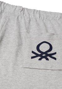Shorts en tissu gris avec une taille élastique et une poche arrière présentant un design de logo abstrait noir.
