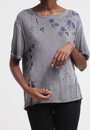 Graues T-Shirt mit kurzen Ärmeln aus weichem Stoff, das vorne und hinten mit einem floralen Muster in Marineblau verziert ist, mit lockerem Schnitt und rundem Ausschnitt.