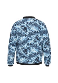 Giacca bomber blu e nera con motivo, caratterizzata da un tessuto liscio, colletto e polsini a coste, con disegni astratti simili a nuvole su tutta la superficie.