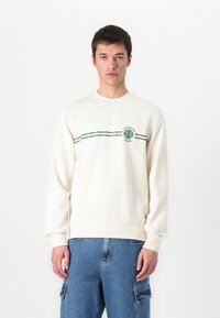 Cream sweatshirt with green stripes and a tennis-themed logo. Made of soft material, featuring a round neckline and ribbed cuffs.