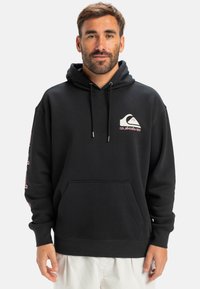 Black hoodie with a front pocket, adjustable drawstrings, and logo in white and pink. Features ribbed cuffs and hem. Soft fabric texture.