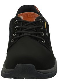 Zapato negro con cordones, con parte superior de cuero texturizado, puntera reforzada y suela de goma. Presenta un detalle de marca en marrón en la lengüeta.