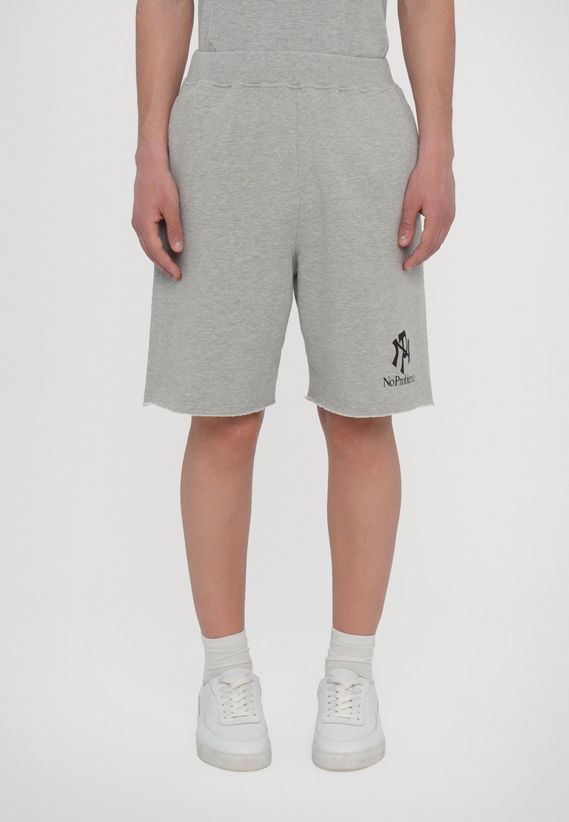 Gray sweat shorts made of cotton blend with an elastic waistband, side pockets, and a raw hem. Features a black logo graphic.