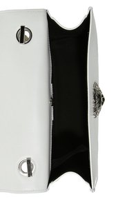 Valkoinen nahkainen käsilaukku kromisilla yksityiskohdilla, jossa on leijonanpään koriste ja musta sisusta. Avotyyppinen muotoilu paljastaa säilytystilan.