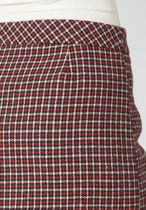 Punane ja must houndstooth-musteriga kangas valgete aktsentidega; sile tekstuur; elastne vöökoht; keskmise kõrgusega disain.