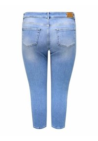 Jeans de mezclilla azul claro con un corte ajustado, cinco bolsillos y una cintura. La tela tiene una textura suave con un ligero desgaste cerca de los muslos.