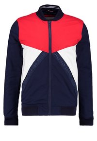 Chaqueta bomber azul marino con paneles rojos y blancos, cierre de cremallera, cuello acanalado y detalle de logotipo bordado. Tejido suave y texturizado.