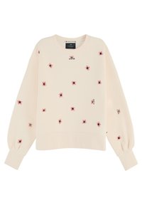 Sweatshirt beige à manches longues, col rond, avec des araignées rouges brodées. Présente des poignets et un ourlet côtelés. Étiquette de la marque visible sur le dessus.