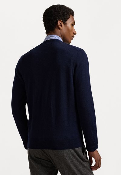 Navy blue lightweight knit sweater with long sleeves and ribbed cuffs, featuring a rounded neckline and a smooth texture.