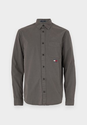 Siva dolgi rokav s krompirjem iz bombaža, ki ima žep na prsih in majhno večbarvno oznako na žepu.