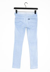 Ljusblå skinny jeans på en svart galge, med en slät denimtextur, subtila bakfickor och en avslagen finish.