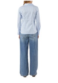 Light blue striped shirt with long sleeves, paired with wide-leg light blue denim jeans. Tailored fit with a structured collar and button cuffs.