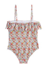 Maillot de bain une pièce à motifs floraux rouges, bleus et jaunes sur fond blanc. Il présente un col à volants et des bretelles fines.