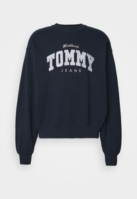 Felpa blu navy realizzata in cotone, con la scritta "TOMMY JEANS" in grandi lettere chiare sul davanti.