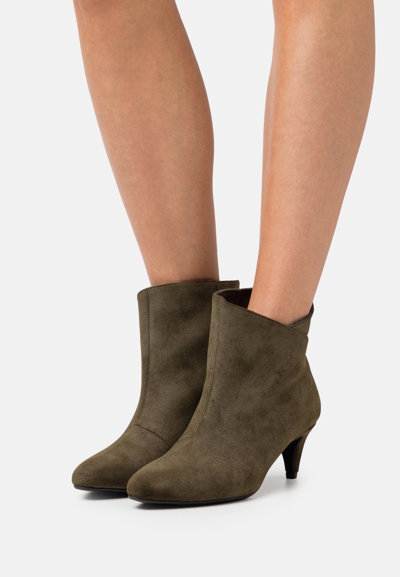 Kotníkové boty z olivově zelené semiše se špičatou špičkou a kuželovým podpatkem vysokým 5 cm; elegantní design s prošitým švem vpředu.