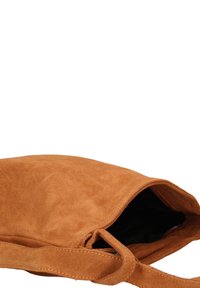 Borsa in suede marrone caldo con una consistenza morbida, dotata di apertura superiore e di una tracolla semplice, progettata con hardware minimo.