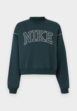 Tmavomodrý skrátený sveter vyrobený z mäkkého materiálu s vysokým golierom, ktorý má na hrudi veľké biele logo "NIKE".