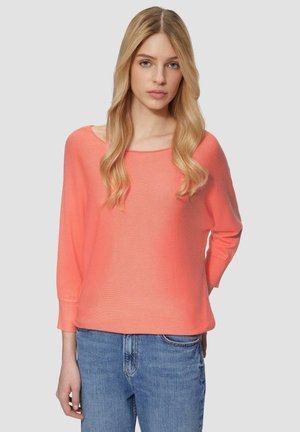Maglione a maglia corallo con scollatura ampia e maniche 3/4, abbinato a jeans di denim blu. Tessuto morbido con vestibilità comoda.