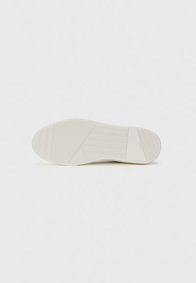 White shoe sole with multiple textured patterns, including wavy and diagonal lines, displayed against a plain white background.