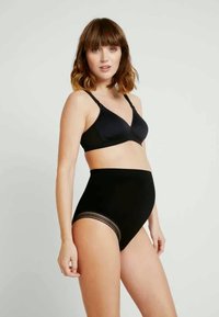 Černá těhotenská podprsenka s měkkou texturou a nastavovacími ramínky, doplněná o černé vysoké kalhotky s průhlednými pruhovanými detaily.
