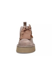 Stivale alla caviglia color taupe chiaro con punta arrotondata, suola spessa beige e lacci marroni testurizzati. Presenta un cappio per facilitare l'indossamento.