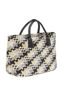 Geweven totebag met een geometrisch patroon in zwart, wit, goud en zilver. Zwarte leren handvatten en een gestructureerde vorm.