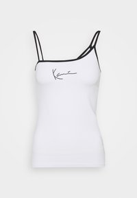 Biały top na ramiączkach z czarnymi akcentami, z cienkimi ramiączkami i ukośnym wzorem. Z przodu znajduje się czarny logo w stylu odręcznym.