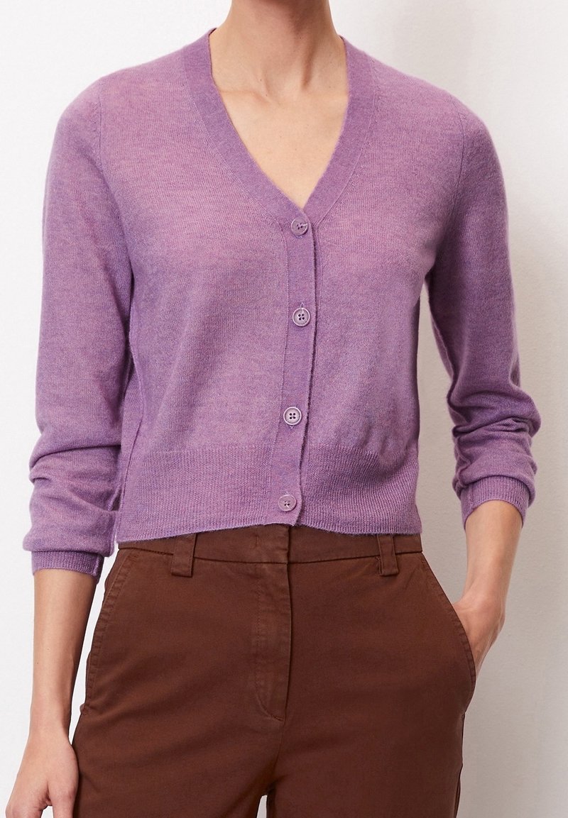 Lila cardigan med v-ringning, långa ärmar och sex knappar framtill. Mjuk textur med en något figurnära design.