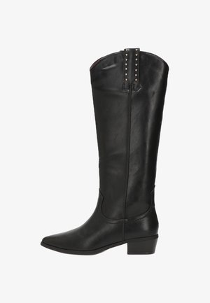 Bota negra de cuero hasta la rodilla con punta afilada, tacón bajo cuadrado y detalles de tachuelas en la parte superior. Textura suave con un diseño elegante.