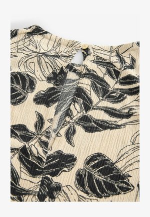 Tissu noir et blanc à motif de feuilles avec une surface texturée et nervurée ; présente une fermeture à bouton au niveau du cou à l'arrière.