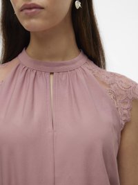 Blusa rosa pallido con un design plissettato, scollatura a chiave e delicate inserti in pizzo sulle spalle. Tessuto morbido e leggero.