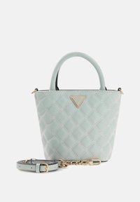 Gequilte handtas in muntgroen met gouden hardware, dubbele handvatten en afneembare riem. Voorzien van een driehoekige logoplaat aan de voorkant.