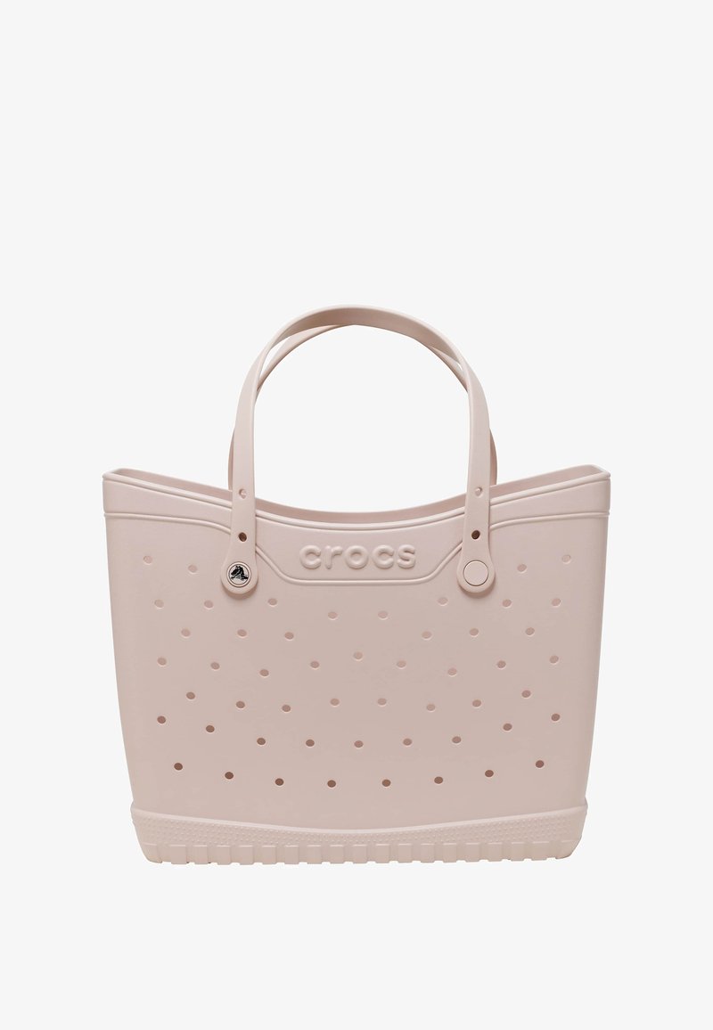 Rosa Gummitasche mit durchlöchertem Design, runden Griffen und einem stabilen Boden mit Rutschfestigkeit, beschriftet mit "crocs."