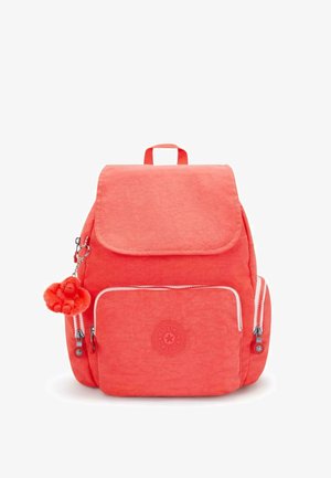 Koralikowy plecak z materiału w kolorze koralowym, z przednią kieszenią na zamek, klapą oraz okrągłym logo. Posiada przywieszkę w kształcie małpki przymocowaną do zamka.