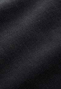 Tissu noir texturé avec un motif côtelé fin, présentant une sensation douce et un léger éclat. Convient à diverses applications vestimentaires.