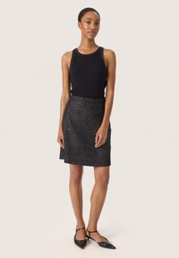 Must mustriba tank top koos musta sädelevate seelikuga, millel on hästi istuv talje ja laienev A-line kuju, mida täiustavad mustad terava ninaga baleriinad.