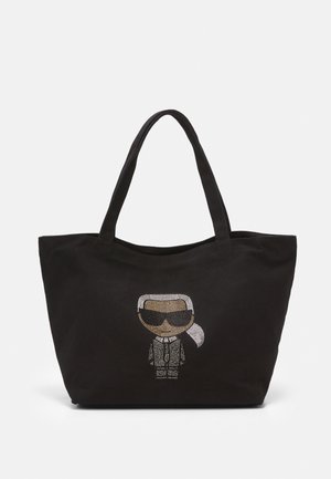 Sac fourre-tout noir avec doubles poignées, orné à l'avant d'une figure de dessin animé cloutée de strass portant des lunettes de soleil et un costume.
