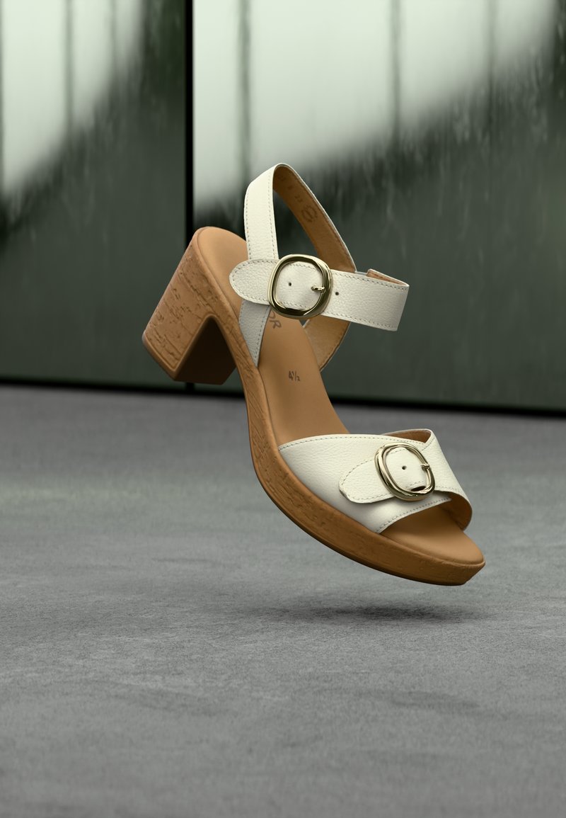 Sandales blanches en cuir à talon bloc avec deux brides ajustables munies de boucles rondes dorées, semelle texturée beige et design à bout ouvert.