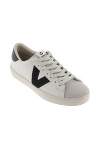 Vit lädersneaker med svart mocka logotyp, grå tåskydd och beige sula. Har snörningsdesign och vadderad tunga för komfort.