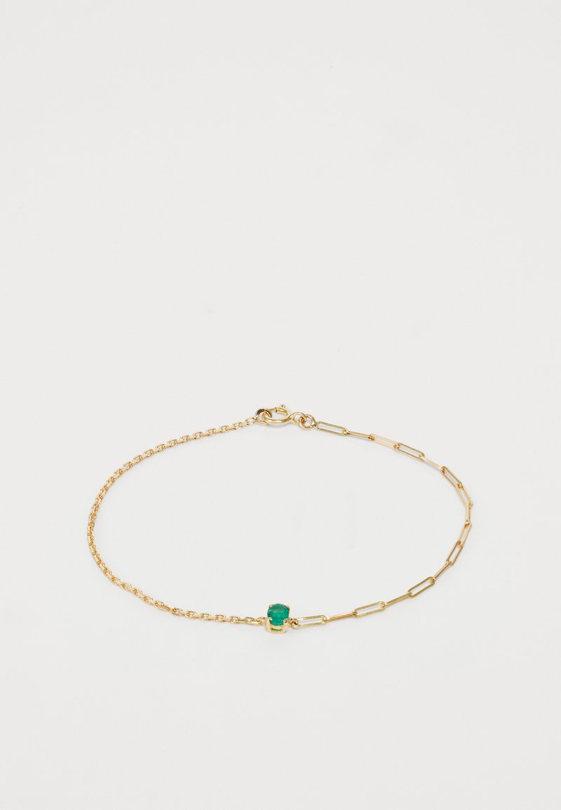 Zelta ķēdītes aproce ar saitēm un mazu zaļu akmeni, ar atsperu aizdari. Rakstainais dizains ar dažādām saites formām.